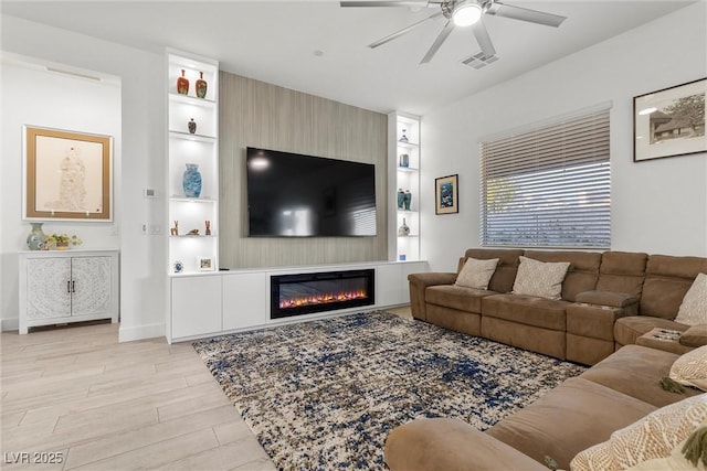 living room with ceiling fan, light hardwood / wood-style floors, and a fireplace