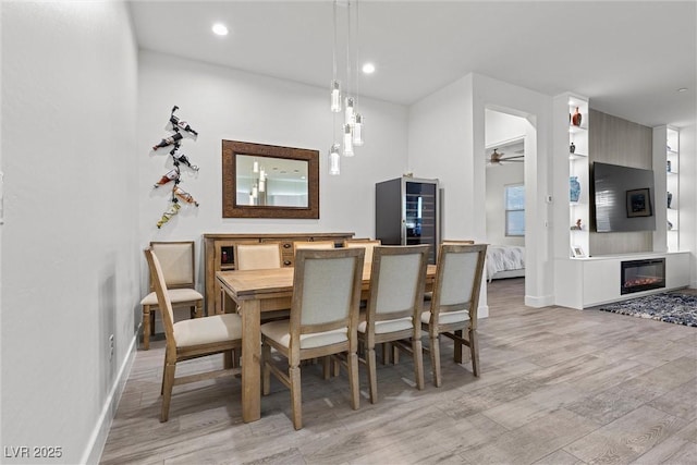 dining space with ceiling fan, light hardwood / wood-style flooring, and wine cooler