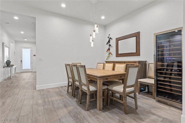 dining room with light hardwood / wood-style floors and beverage cooler