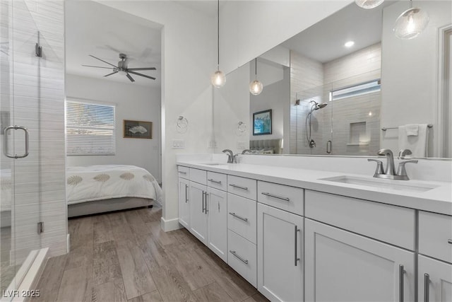 bathroom with ceiling fan, wood-type flooring, vanity, and a shower with door