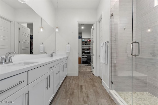 bathroom with hardwood / wood-style flooring, a shower with door, and vanity