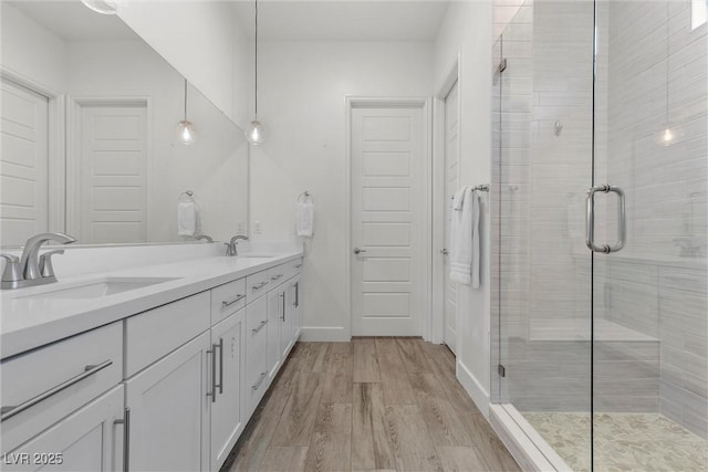 bathroom with an enclosed shower, vanity, and hardwood / wood-style floors