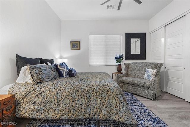 bedroom featuring ceiling fan, a closet, and hardwood / wood-style flooring