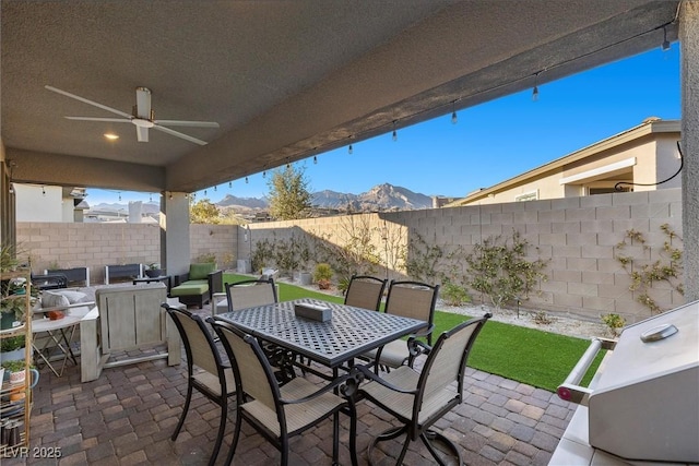 view of patio / terrace featuring ceiling fan and a mountain view