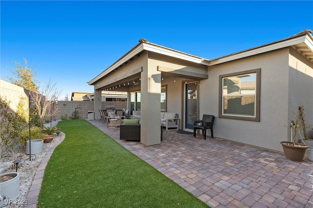 exterior space with a patio area, outdoor lounge area, and a lawn