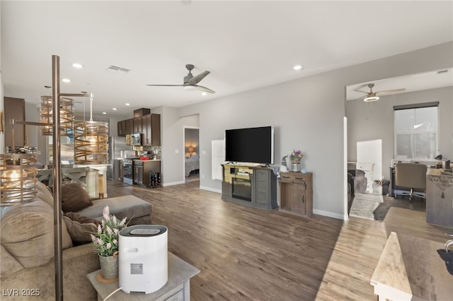 living room with ceiling fan and hardwood / wood-style flooring