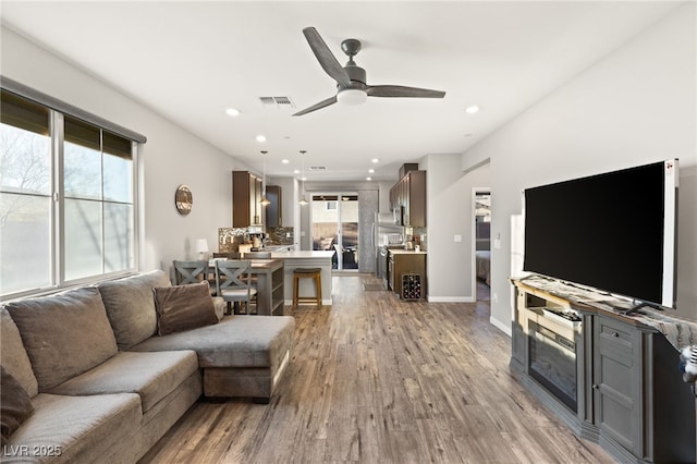 living room featuring light hardwood / wood-style floors and ceiling fan