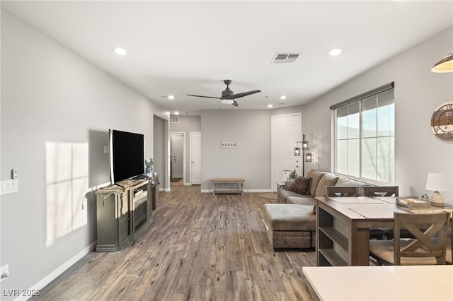 living room featuring ceiling fan and hardwood / wood-style flooring