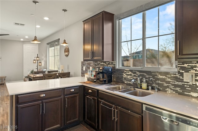 kitchen with dishwasher, kitchen peninsula, dark brown cabinetry, sink, and decorative light fixtures