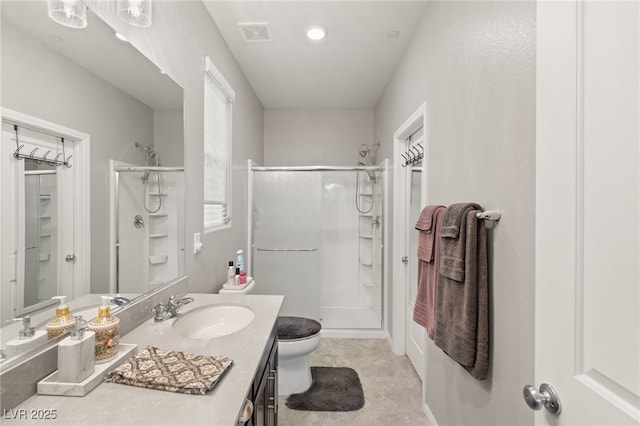 bathroom with toilet, a shower with door, and vanity