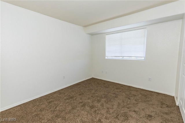 spare room with dark carpet