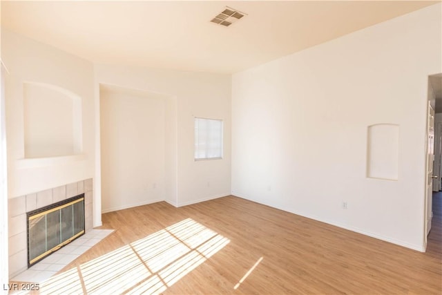 unfurnished living room with a fireplace and light hardwood / wood-style floors