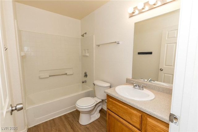 full bathroom featuring toilet, hardwood / wood-style flooring, washtub / shower combination, and vanity