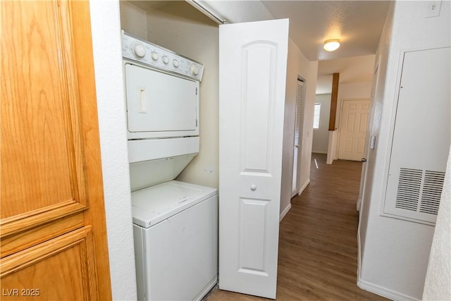 clothes washing area with hardwood / wood-style floors and stacked washer / drying machine