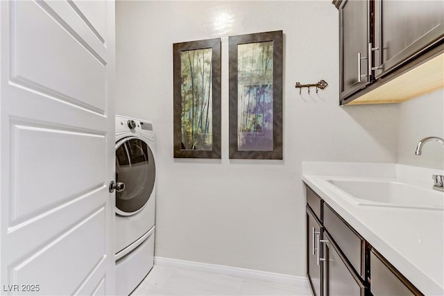 washroom featuring washer / dryer, cabinets, and sink