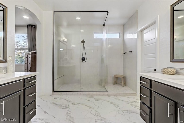 bathroom featuring vanity, walk in shower, and a wealth of natural light