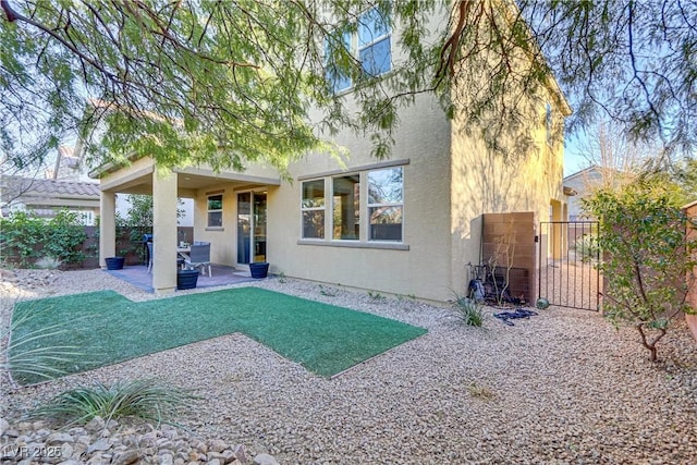 rear view of house featuring a patio and a yard