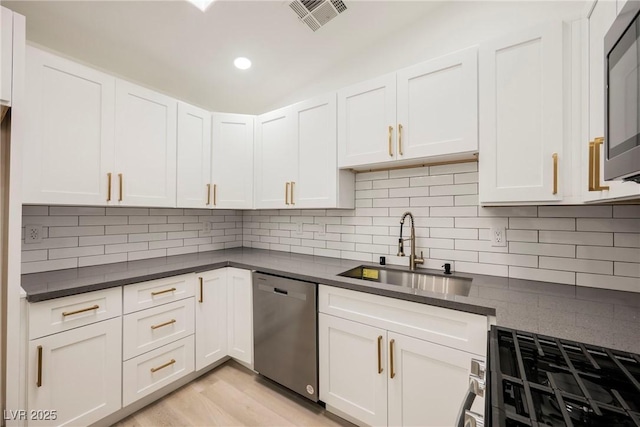 kitchen featuring sink, white cabinetry, dishwasher, and decorative backsplash