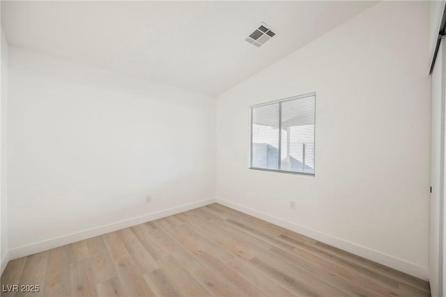 unfurnished room featuring light wood-type flooring and vaulted ceiling