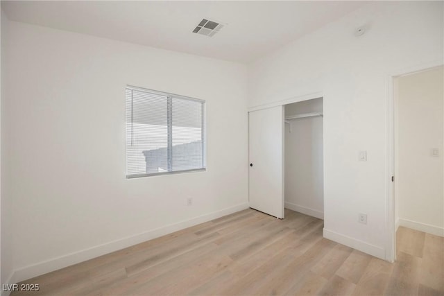 unfurnished bedroom with light hardwood / wood-style floors and a closet