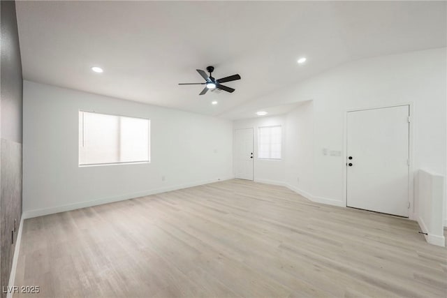 empty room with lofted ceiling, plenty of natural light, and light hardwood / wood-style flooring