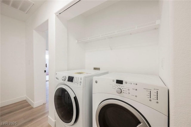 washroom featuring light hardwood / wood-style flooring and washer and clothes dryer