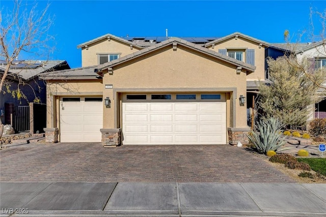 view of front facade featuring decorative driveway, stone siding, and stucco siding