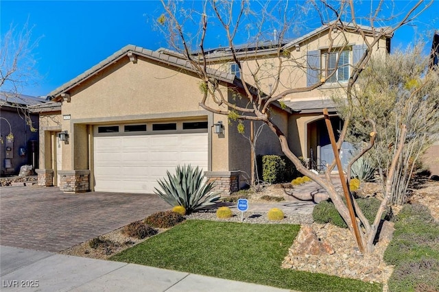 view of front of property featuring roof mounted solar panels, stucco siding, decorative driveway, and a garage