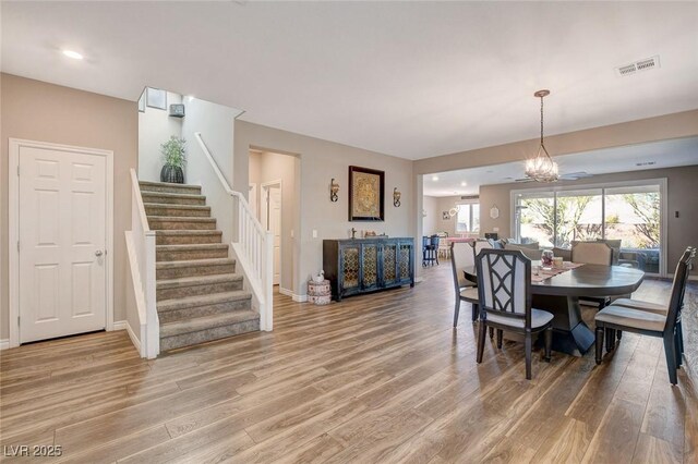 dining space with wood-type flooring and an inviting chandelier