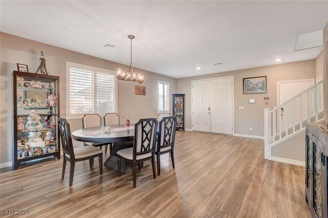 dining space featuring a notable chandelier and light hardwood / wood-style floors