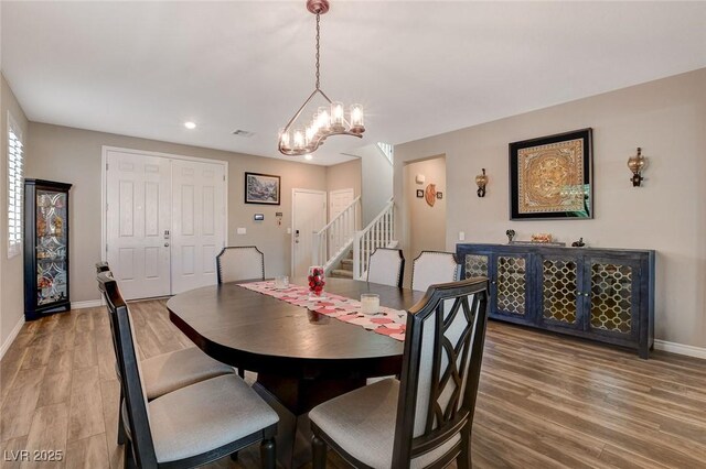 dining room with an inviting chandelier and wood-type flooring