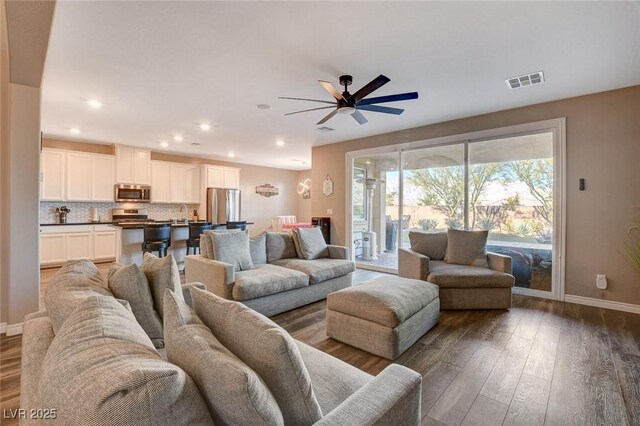 living room with ceiling fan, dark wood-type flooring, and sink