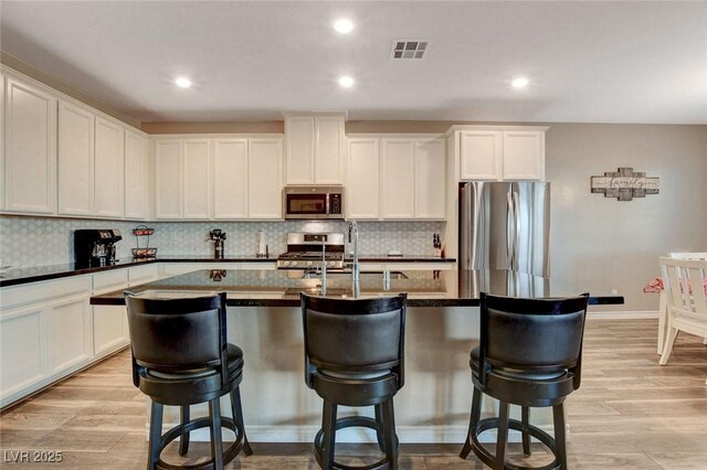 kitchen with white cabinets, stainless steel appliances, light hardwood / wood-style flooring, and sink