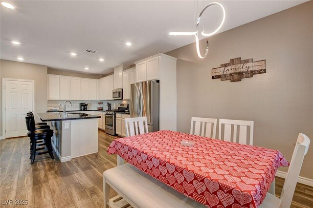 dining room featuring wood-type flooring and sink