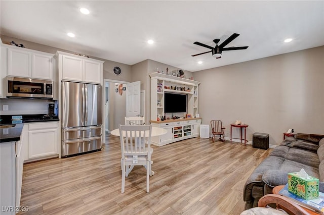 living room featuring ceiling fan and light hardwood / wood-style floors