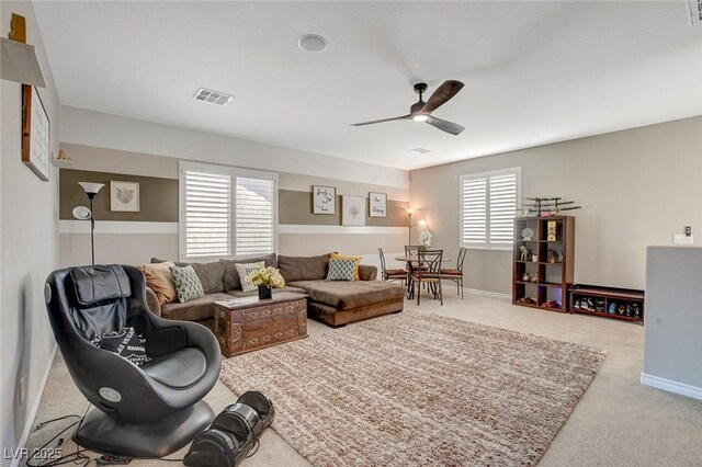 living room with ceiling fan, a healthy amount of sunlight, and light carpet