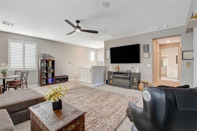 living room featuring ceiling fan and light colored carpet