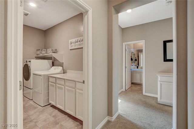 laundry area with light colored carpet, cabinets, and independent washer and dryer