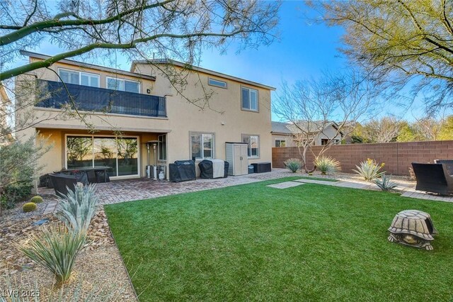 back of house featuring a yard, a balcony, a jacuzzi, and a patio