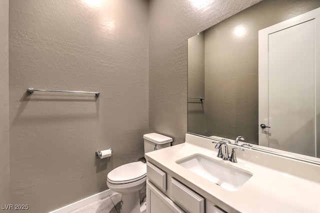 bathroom with toilet, tile patterned flooring, and vanity