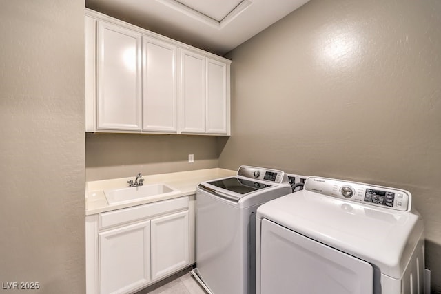 laundry area with sink, cabinets, and washer and clothes dryer