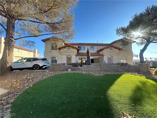 mediterranean / spanish-style house with a front lawn