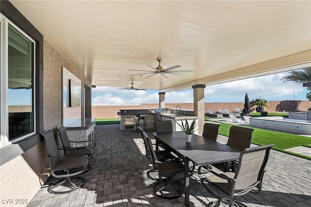 view of patio with ceiling fan, an outdoor kitchen, and a grill