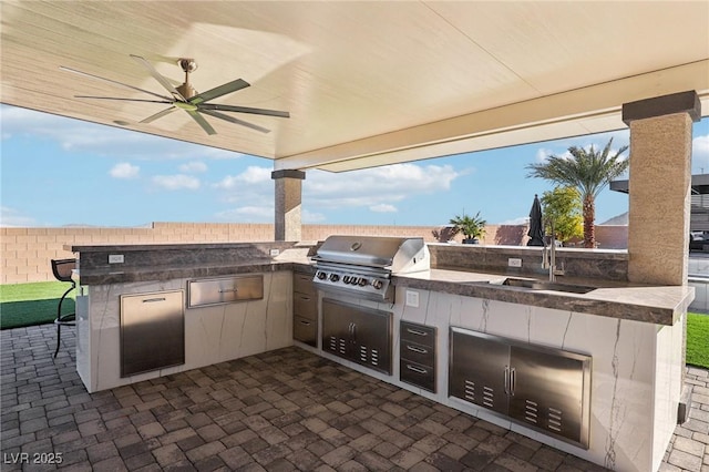 view of patio featuring ceiling fan, exterior kitchen, sink, and a grill