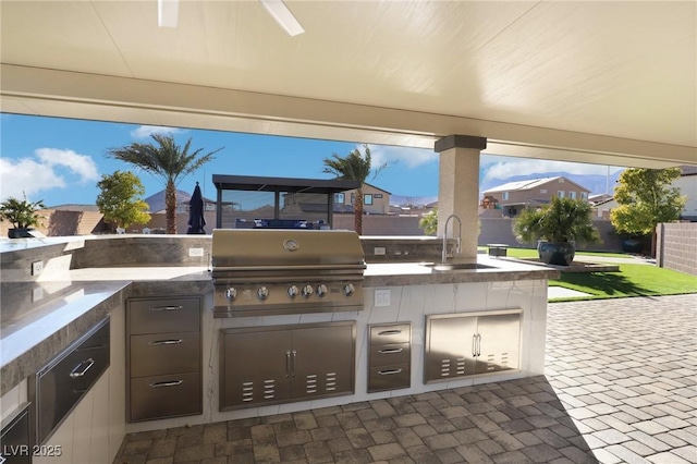 view of patio with sink, exterior kitchen, and a grill