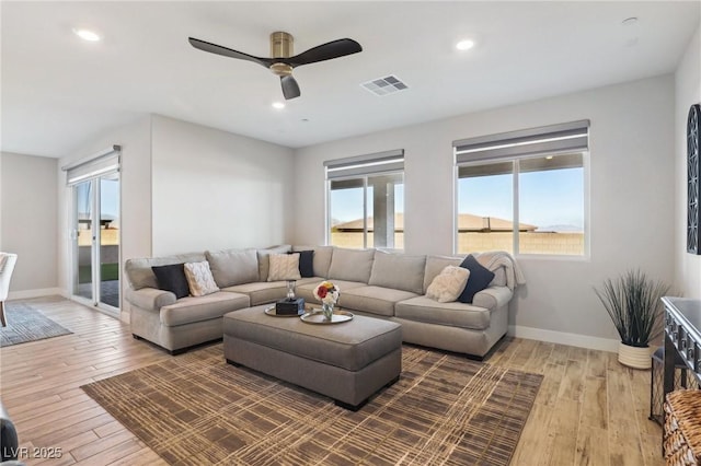 living room with hardwood / wood-style flooring, a healthy amount of sunlight, and ceiling fan