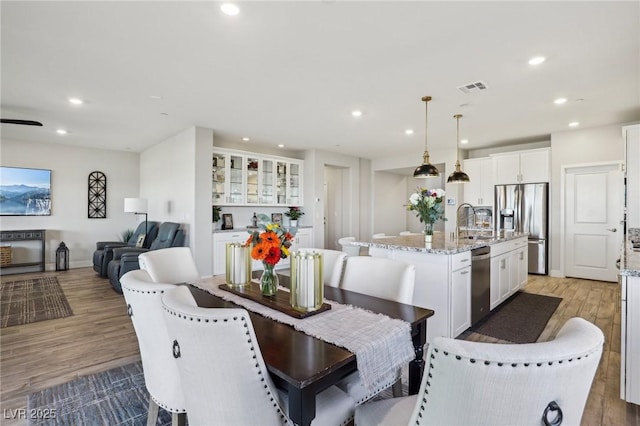 dining space with sink and light wood-type flooring