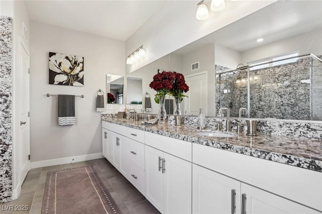 bathroom featuring tile patterned floors, a shower with door, and vanity