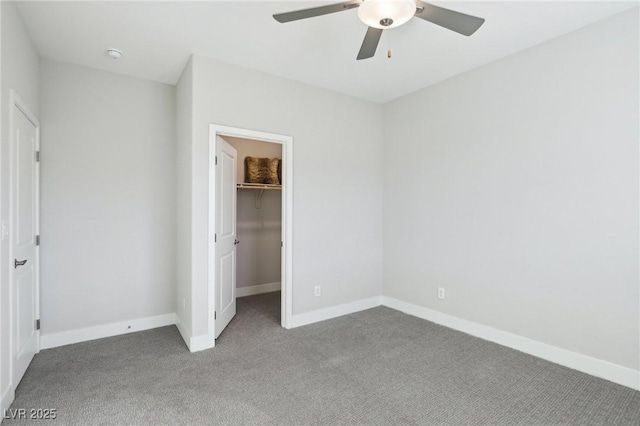 unfurnished bedroom featuring ceiling fan, a closet, a walk in closet, and carpet floors