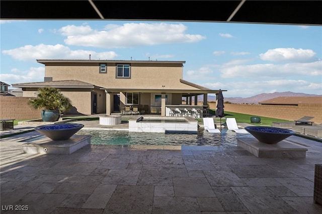 view of pool with a bar, a hot tub, a patio, a mountain view, and pool water feature